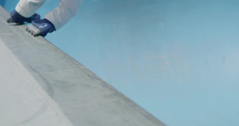 A person grinds on the side of the empty pool