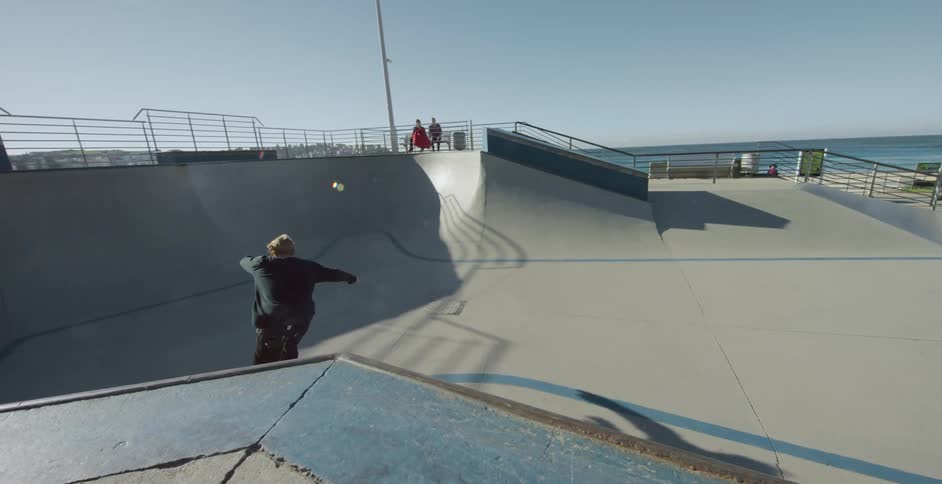 Man rollerblades and jumps off in the skate park