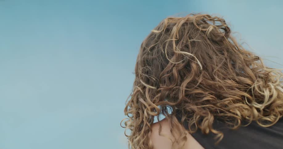 A person is looking up at the sky on a windy day