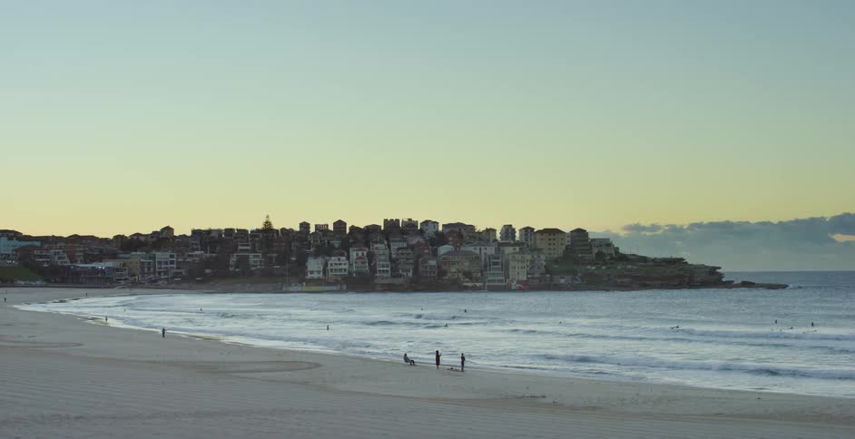 People are on the beach near the city