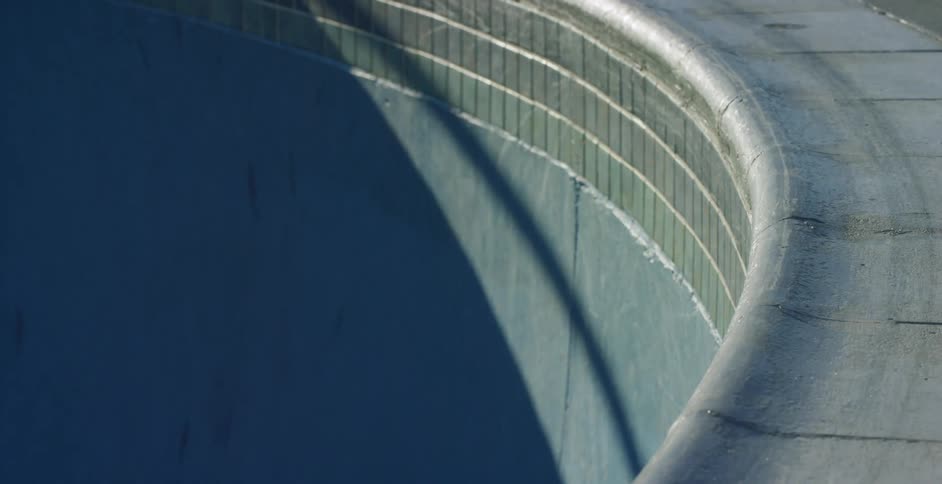 An empty pool with the sun shining off of it