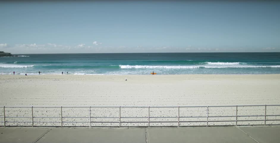 A boardwalk with the beach and people in the background