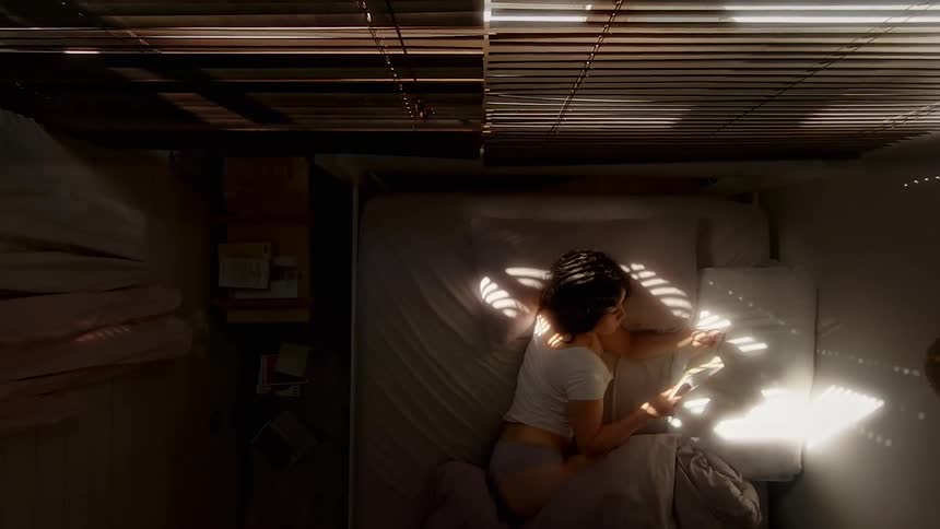 Birds eye view of a teenager lying in bed reading