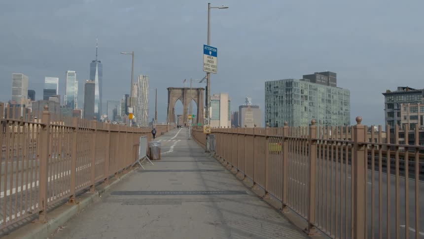 View of a walking path on the brooklyn bridge with skyscrapers in the background