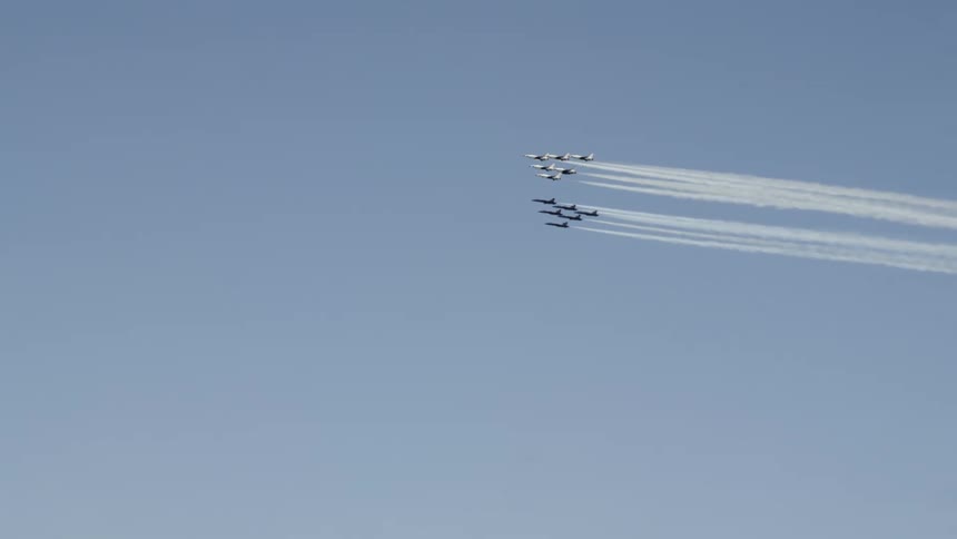 The planes fly in formation over the city
