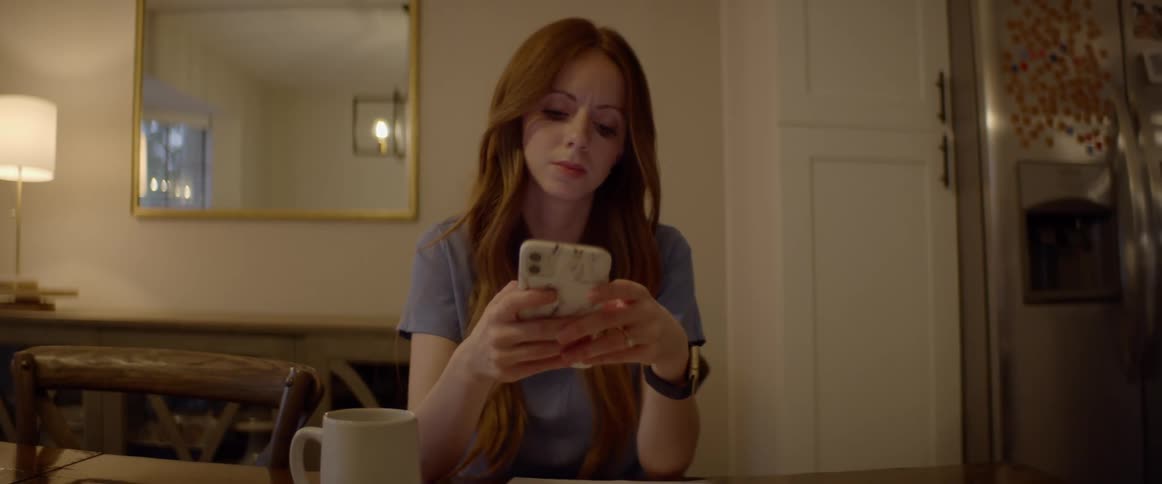 Woman uses smartphone while sitting in apartment living room