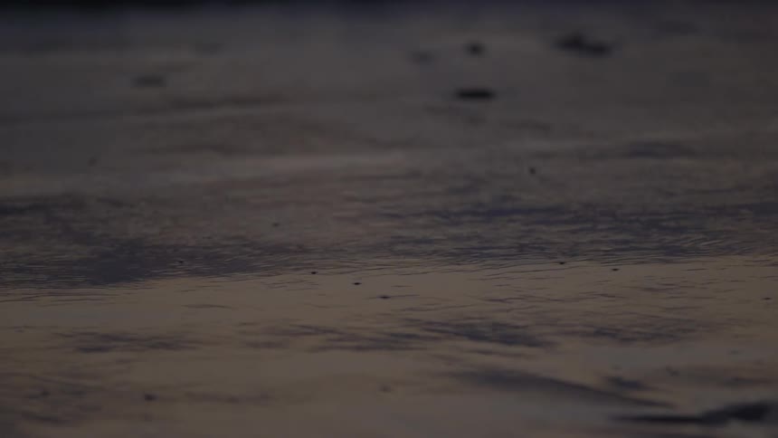 The tide rolling in on a beach at night