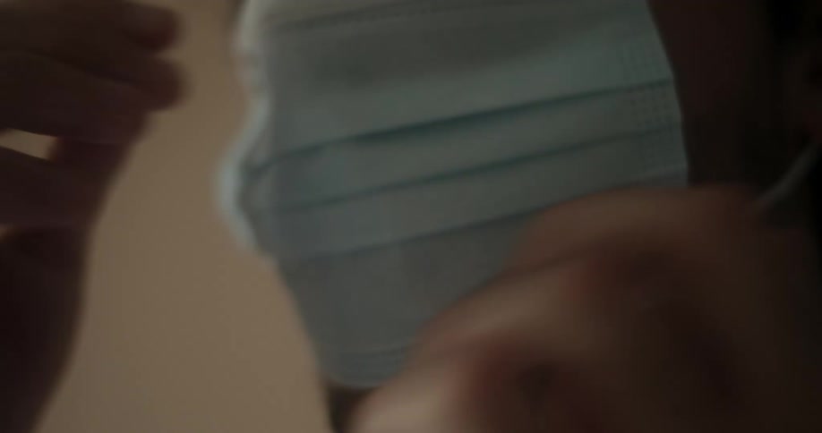 A man putting on and adjusting a medical face mask