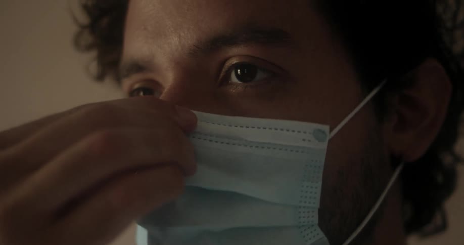 A man puts on a medical mask