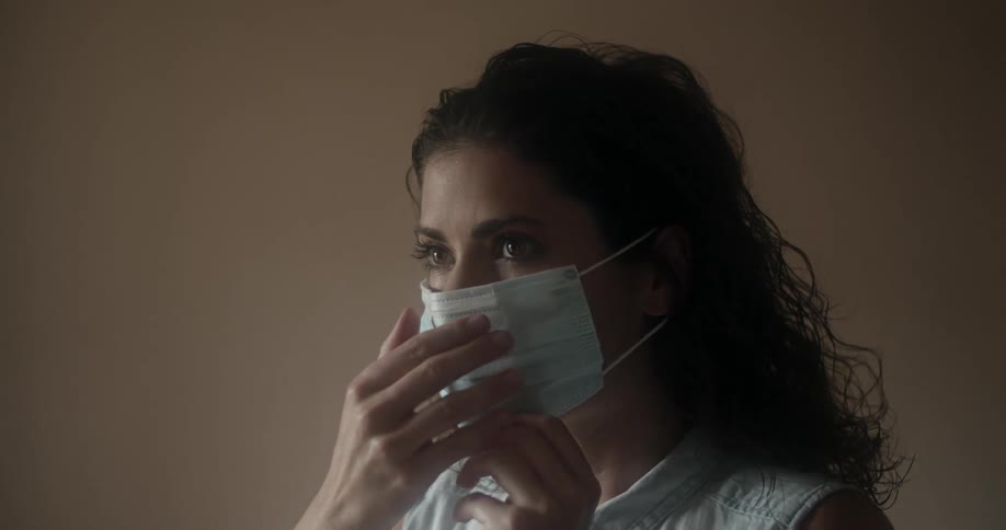 A woman puts on a face mask