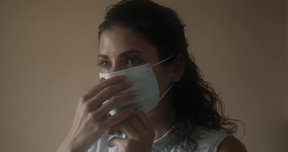 Woman puts on a face mask as a precaution due to coronavirus