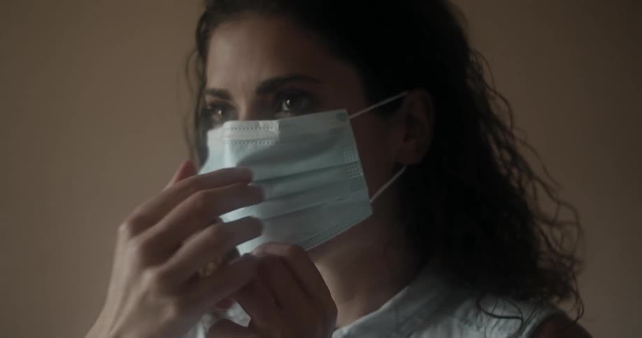 Woman raises face mask and puts it on