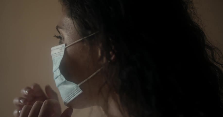 A woman putting on and adjusting a medical face mask