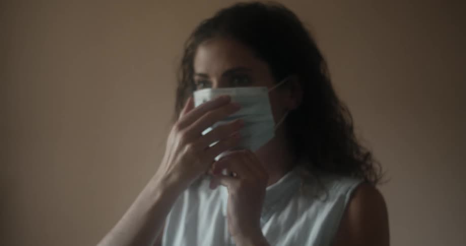 A woman puts on a face mask