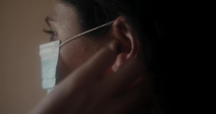A woman puts a face mask on
