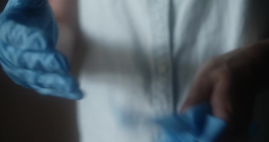 Person takes off blue medical gloves