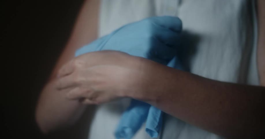 A person removing a pair of latex gloves from her hands