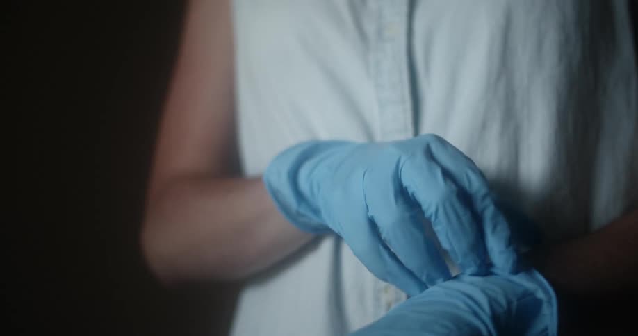 Person tugs latex gloves up their wrists