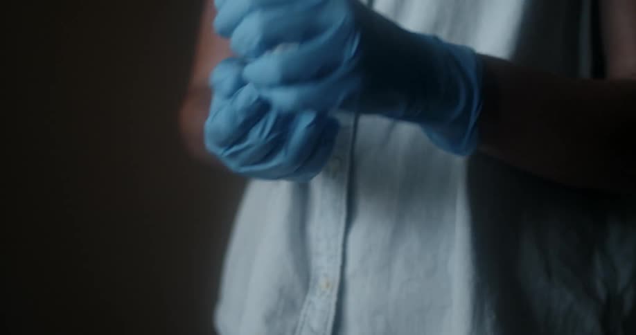 Person pulls latex gloves further up their wrists