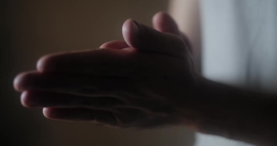 A person spraying and rubbing hand sanitizer over their hands
