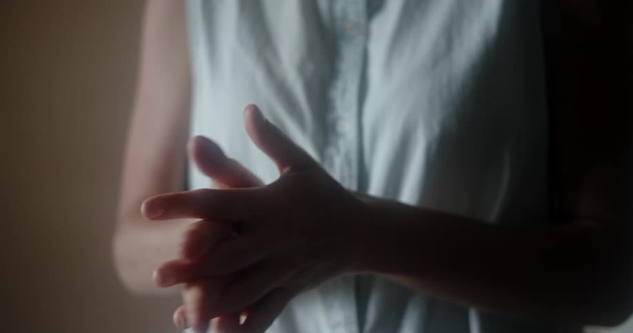 A woman spraying and rubbing hand sanitizer onto her hands