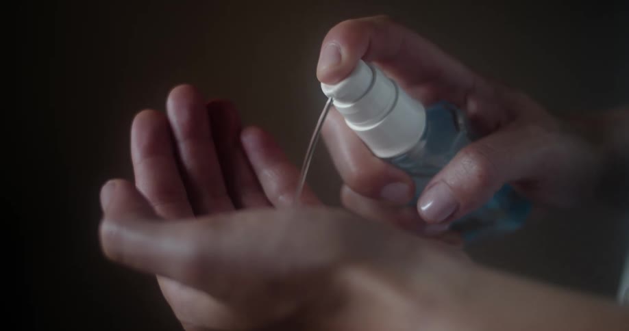 A woman pumps hand sanitizer in to her hand