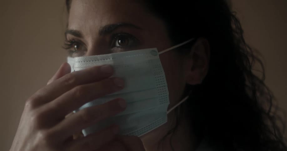 A woman puts on a medical mask