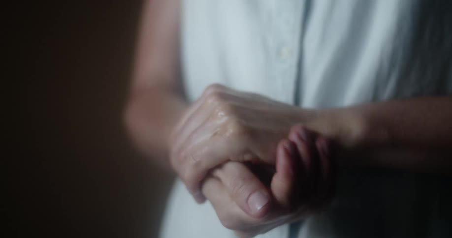A woman sprays hand sanitizer in to her hands and rubs them together