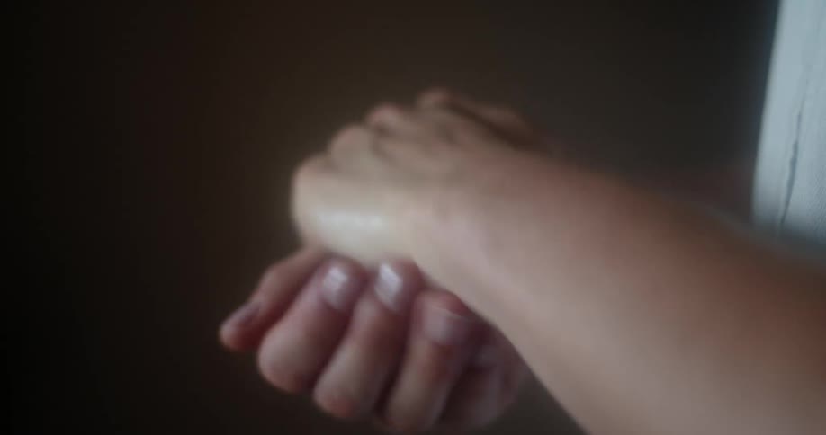 A woman applies a substantial amount of hand sanitizer