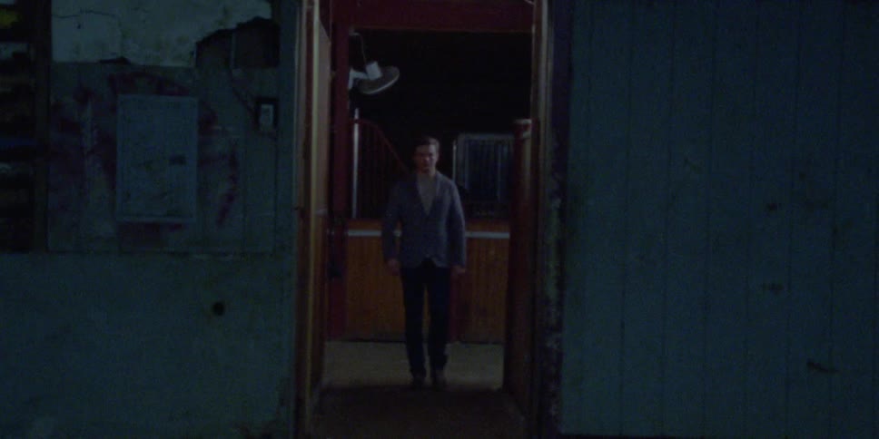 A man walking towards the camera through a short narrow camera
