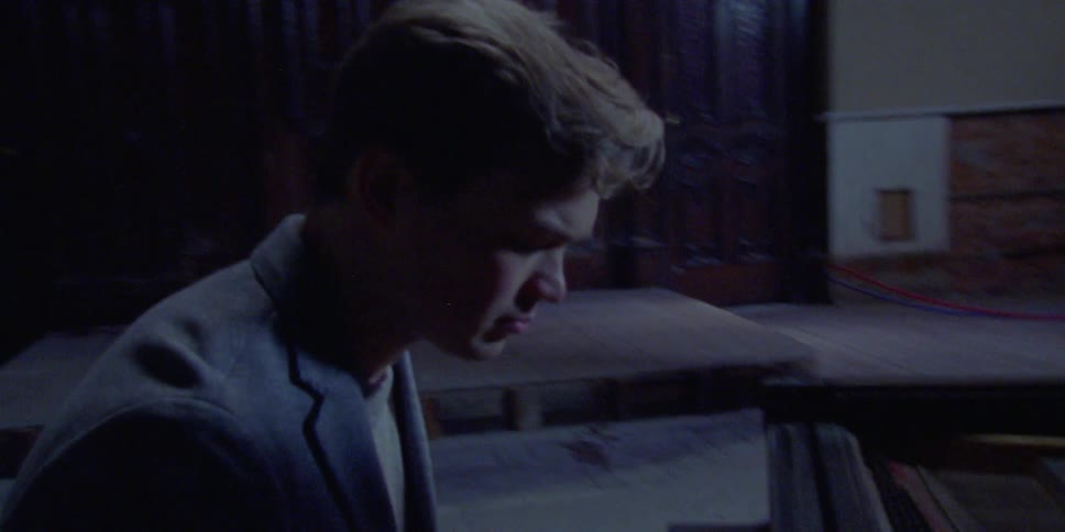 A man plays the piano in an abandoned auditorium