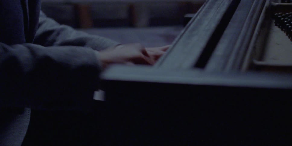 A pianist playing the piano in a dimly lit room