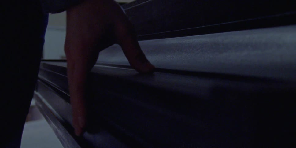 A man lifts up the cover to a piano and sits down to play