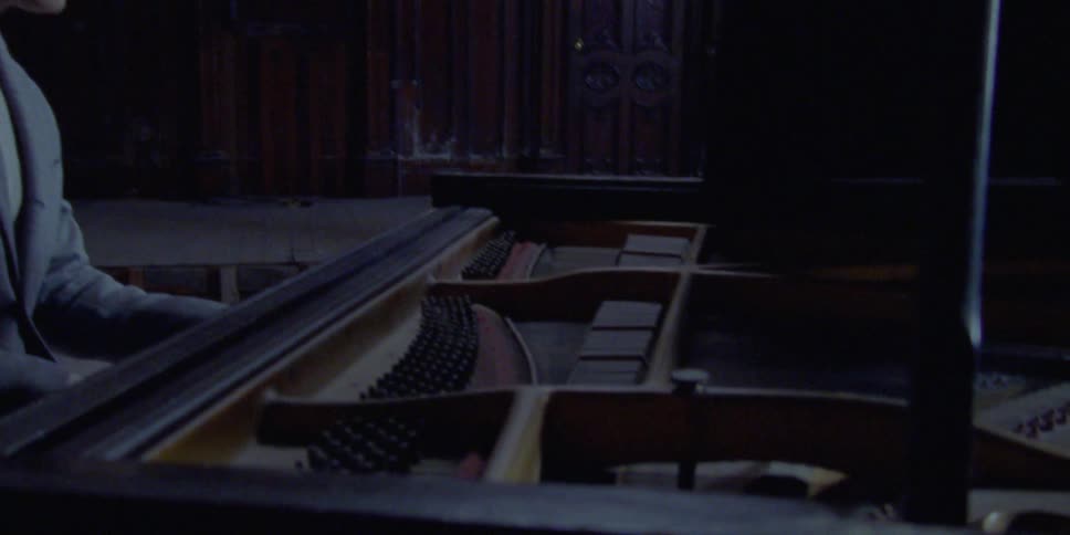 A man plays the piano in an abandoned auditorium