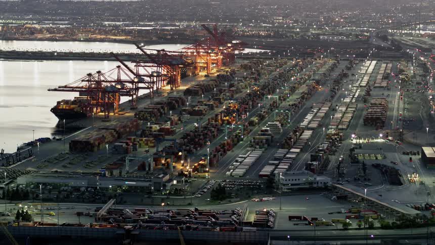 A busy road outside of a shipping yard in the city during the evening