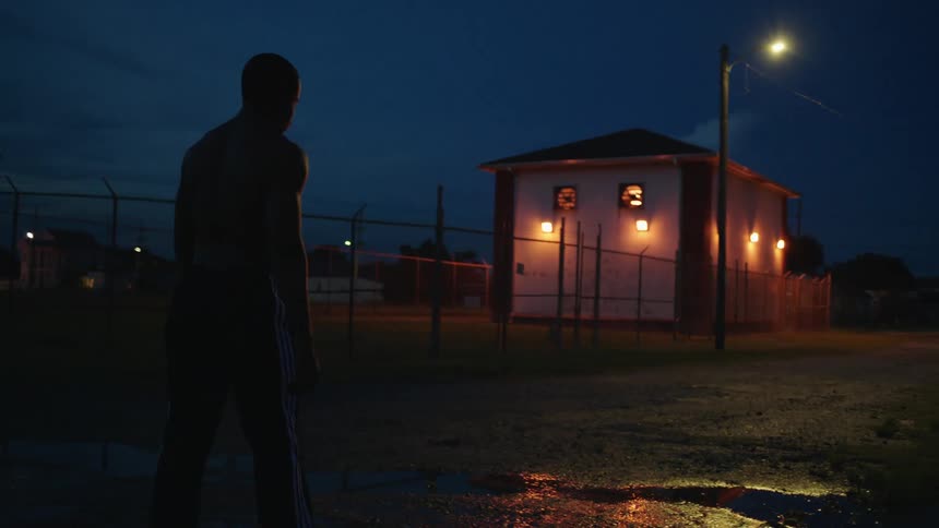 A man stumbles down the road at night