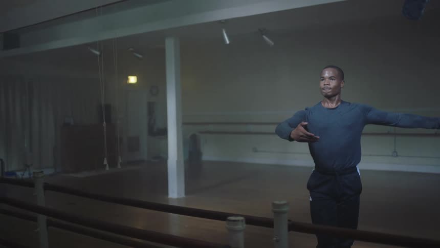 A black male practices ballet in a studio
