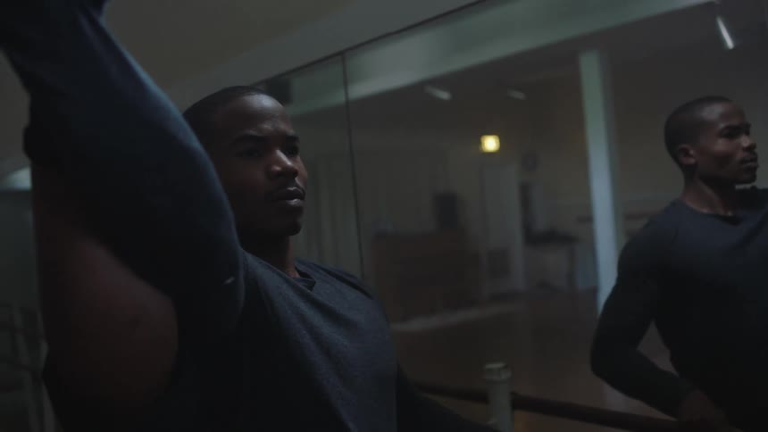 Two men are stretching in a room