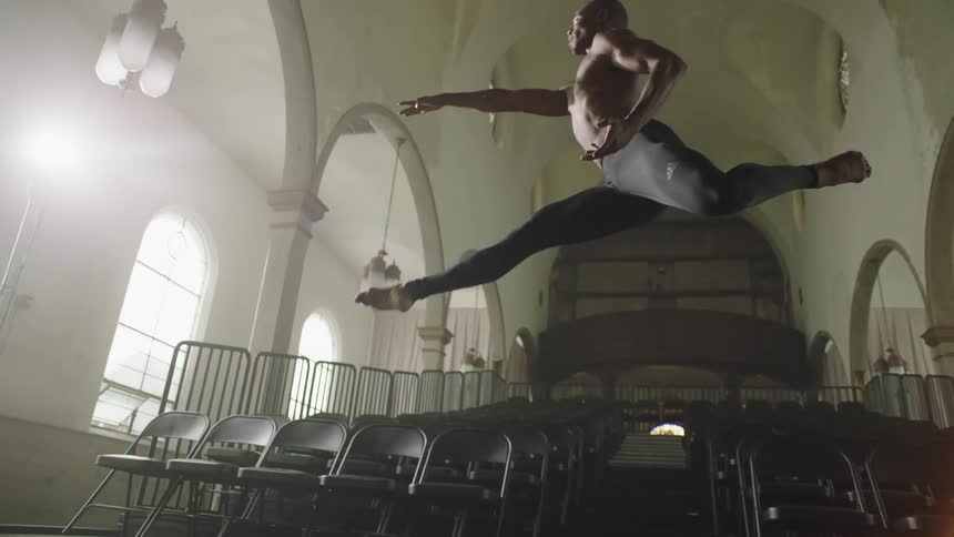 A male dancer doing a graceful leap in an empty building