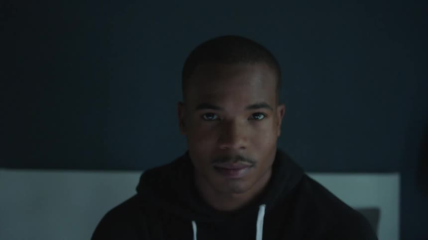 A black man lifts his head and looks straight ahead