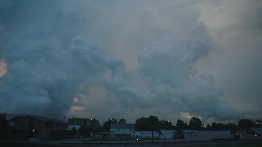 Large clouds in the sky over a neighborhood at sunset