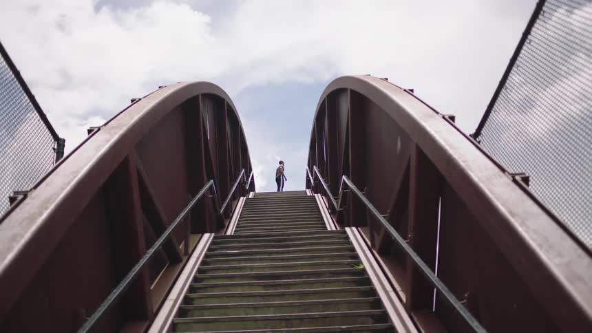 A person stands at the top of the staircase