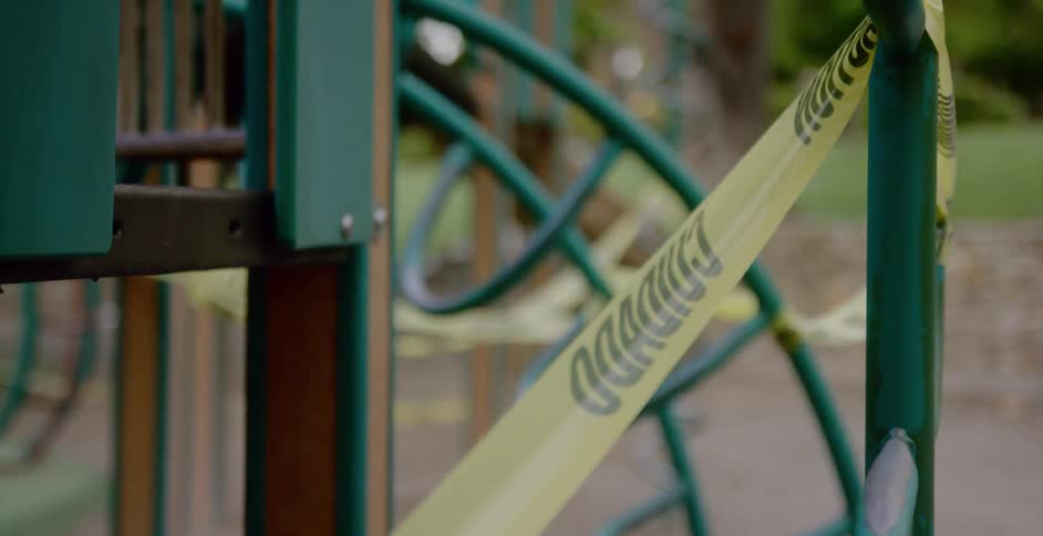 Closeup of caution tape covering a closed playground