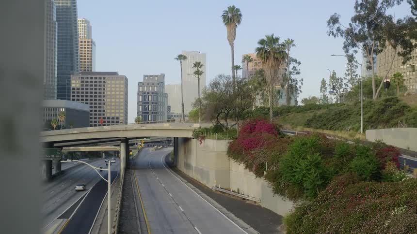 A highway with vehicles with buildings and skyscrapers in the background