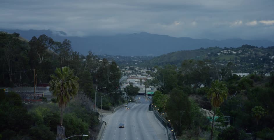 Cars driving down a highway in Los Angeles at dusk