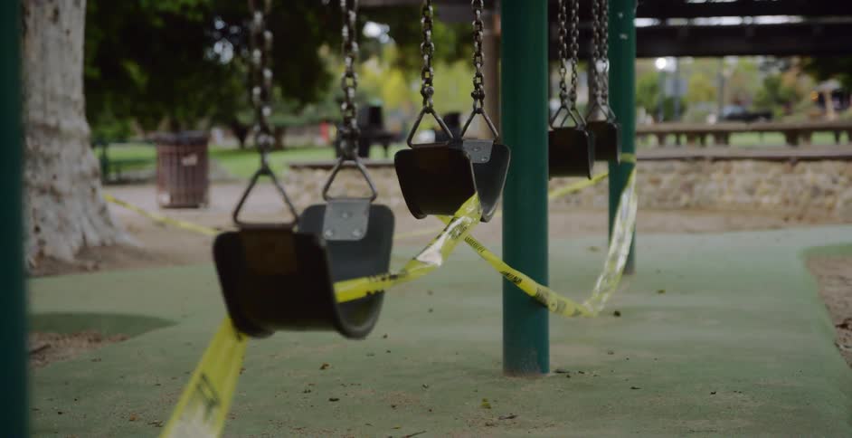 Closeup of swing set covered in caution tape