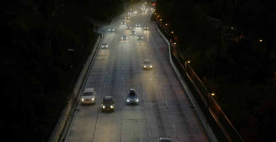 Vehicles drive on multilane highway at night
