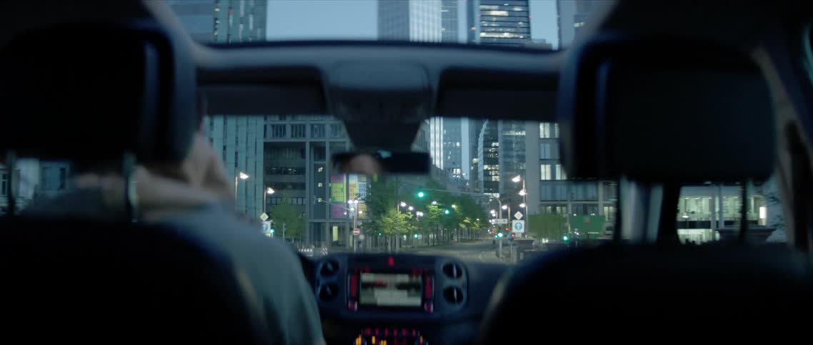 A person is driving a car through a downtown city