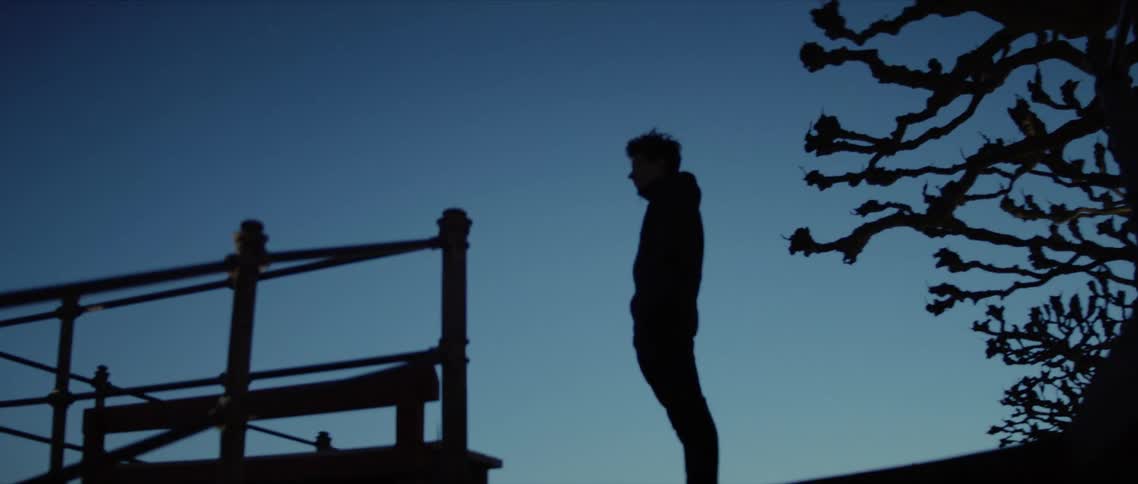 A teenager stands at the top of a staircase