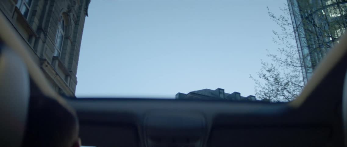 A man drives down a city street